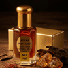 Attar Musk Amber fragrance bottle with golden cap and wood pieces, showcasing musk amber attar fragrance.